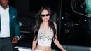 Masih setia dengan rumah mode Chanel, Jennie memilih tampilan yang lebih effortless namun tetap statement. Ia mengenakan cropped lace camisole dengan detail sequin halus yang dipadukan dengan satin midi skirt senada, memperlihatkan siluet midriff yang sleek. Sentuhan edgy hadir lewat knee-high leather boots serta sunglasses, memberi kontras modern pada look yang feminin. [@voguehongkong].