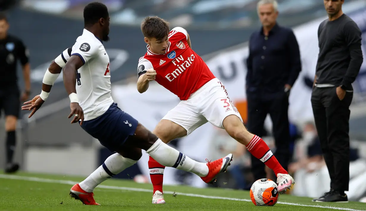 Bek Arsenal, Kieran Tierney berusaha melewati bek Tottenham Hotspur, Serge Aurier pada pertandingan lanjutan Liga Inggris di Stadion Tottenham Hotspur di London, Inggris, Minggu (12/7/2020). Tottenham menang tipis atas Arsenal 2-1. (Tim Goode/Pool via AP)