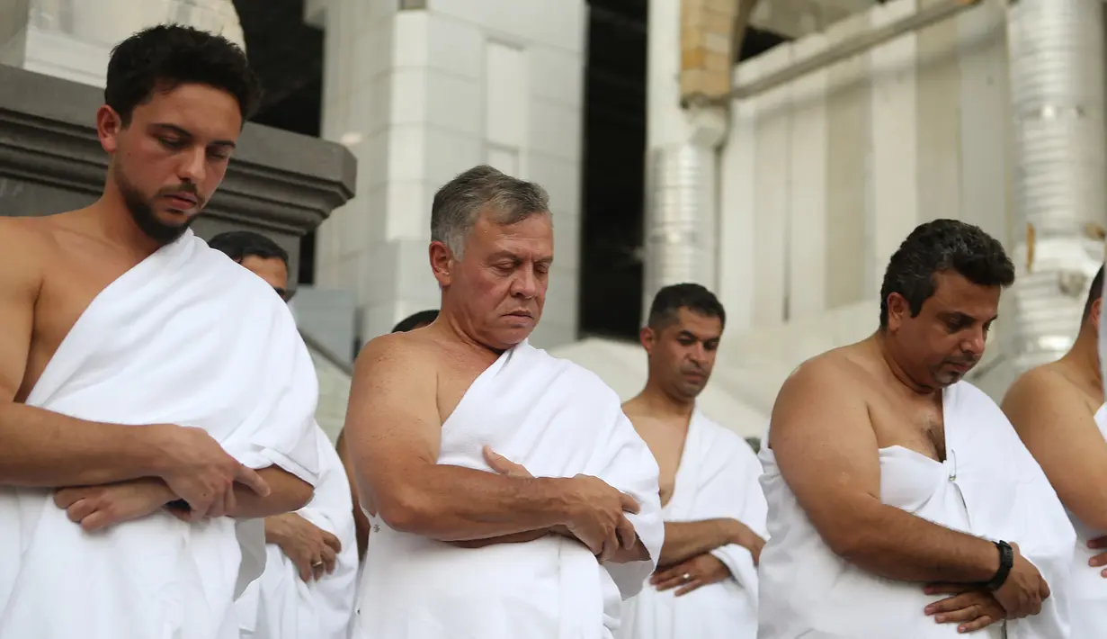 Raja Yordania, Abdullah II bin Al Hussein dan putranya Putra Mahkota Hussein bin Abdullah beribadah salat saat melakukan umrah pada bulan Ramdan di kota suci Mekkah (10/6). (AFP Photo/Jordanian Royal Palace/Yousef Allan)