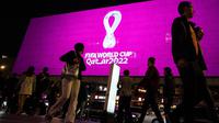 Orang-orang melintasi layar yang menampilkan logo Piala Dunia Qatar 2022, di jalanan New Arbat, pusat kota Moskow di Rusia, Selasa (3/9/2019). Logo tersebut ditampilkan di ruang publik di Qatar dan kota-kota besar seluruh dunia. (AP Photo/Pavel Golovkin)