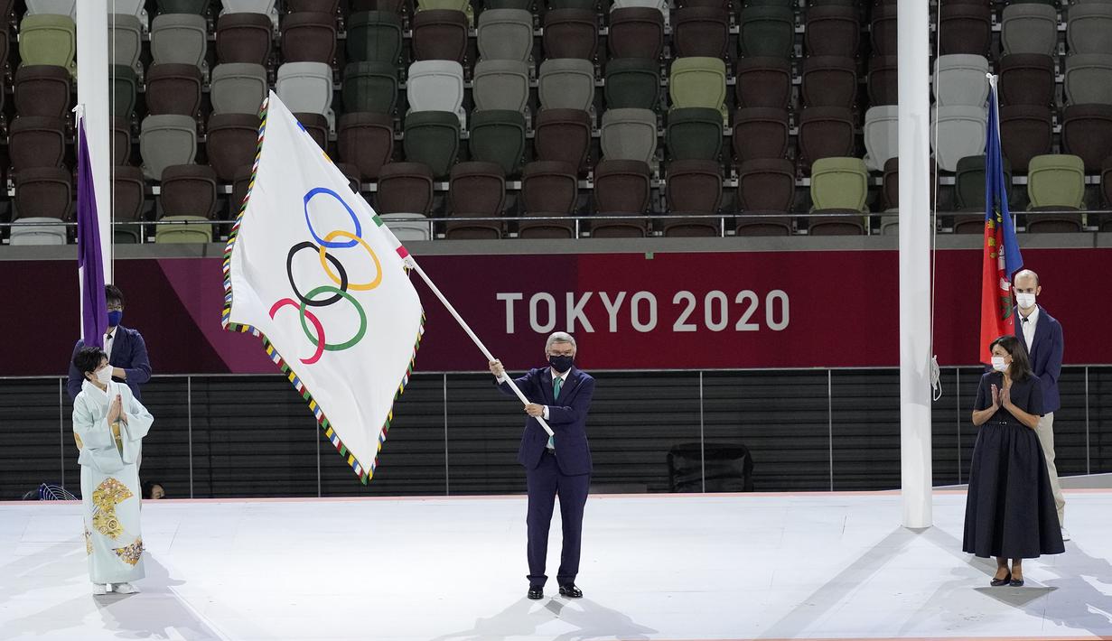 Presiden Komite Olimpiade Internasional Thomas Bach mengibarkan bendera Olimpiade saat Gubernur Tokyo Yuriko Koike (kiri) dan Wali Kota Paris Anne Hidalgo (kanan) menyaksikan upacara penutupan di Stadion Olimpiade pada Olimpiade Musim Panas 2020, Minggu 8 Agustus 2021, di Tokyo. (AP/Lee Jin-man)