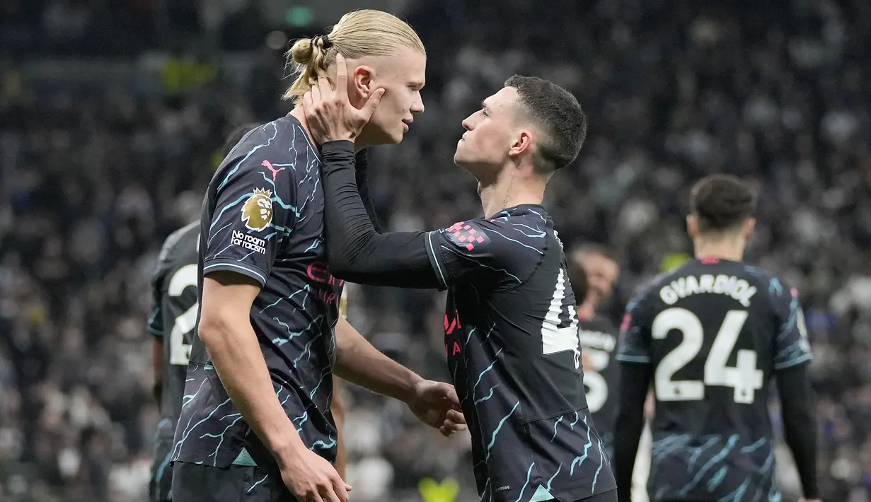 Pemain Manchester City Erling Haaland dan Phil Foden merayakan gol kedua tim mereka yang dicetak ke gawang Tottenham Hotspur dalam laga tunda pekan 34 Premier League 2023/2024 di Tottenham Hotspur Stadium, Rabu (15/5/2024) dini hari WIB. (AP Photo/Kin Cheung)