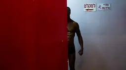 Foto pada 18 Oktober 2018, seorang kontestan mewarnai tubuhnya di belakang panggung kontes binaraga amatir di Tel Aviv, Israel. Pria dan wanita, muda dan tua, Yahudi dan Arab dari seluruh negeri bekerja sama menyiapkan pertunjukan besar. (AP/Oded Balilty)
