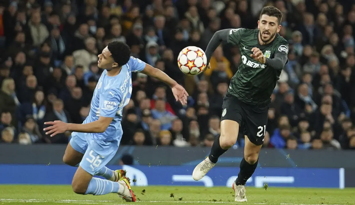 Penyerang Sporting Lisbon Paulinho melewati bek Manchester City Conrad Jaden Egan-Riley pada leg kedua babak 16 besar Liga Champions, Kamis (10/3/2022) dini hari WIB. Manchester City tetap melaju ke perempat final meski bermain imbang 0-0 dengan Sporting Lisbon. (AP Photo/Dave Thompson)