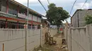 Warga memanjat tembok untuk memasuki rumahnya di kawasan Ciledug, Kota Tangerang, Banten, Senin (15/3/2021). Tembok beton sepanjang 300 meter dengan tinggi 2 meter serta dipasang kawat duri itu menutup akses menuju rumah dan tempat usaha milik warga. (Liputan6.com/Herman Zakharia)