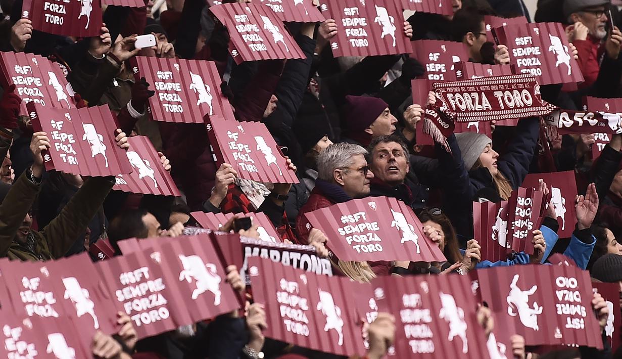 Suporter Torino membawa banner saat mendukung timnya melawan Juventus pada laga Serie A  di Stadio Grande Torino, Turin (18/2/2018). Juventus menang 1-0. (AFP/Marco Bertorello)