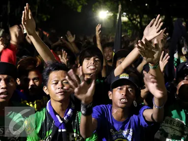 Ratusan pendukung Persebaya bernyanyi menghabiskan malam di GOR Padjajaran, Bandung, Sabtu (7/1). Ribuan suporter Persebaya berkumpul di GOR Padjajaran menunggu keputusan kongres PSSI terkait nasib klub kesayangan mereka. (Liputan6.com/Helmi Fithriansyah)