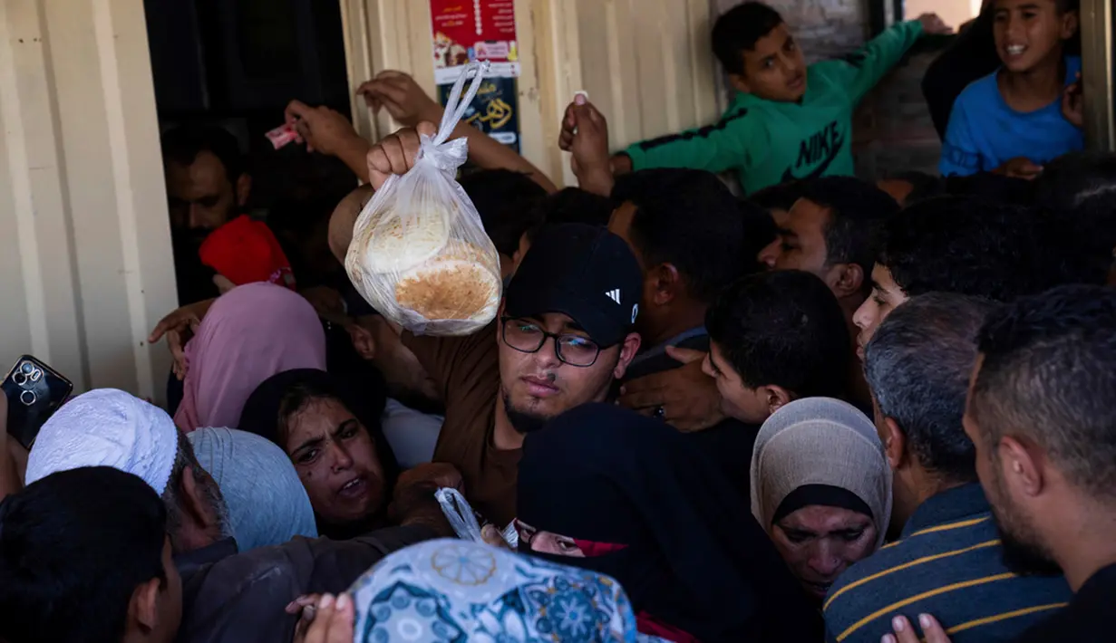 Ini adalah rutinitas yang sangat melelahkan – menunggu berjam-jam untuk mendapatkan roti, mencoba mencari air, menenangkan anak-anak saat terjadi pengeboman. (AP Photo/Fatima Shbair, File)