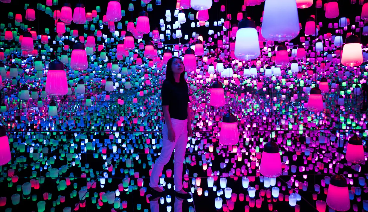 Seorang wanita menikmati ruangan yang penuh instalasi lampu gantung di Mori Building Digital Museum Seni, Tokyo, Jepang (1/5). (AFP Photo/Behrouz Mehri)