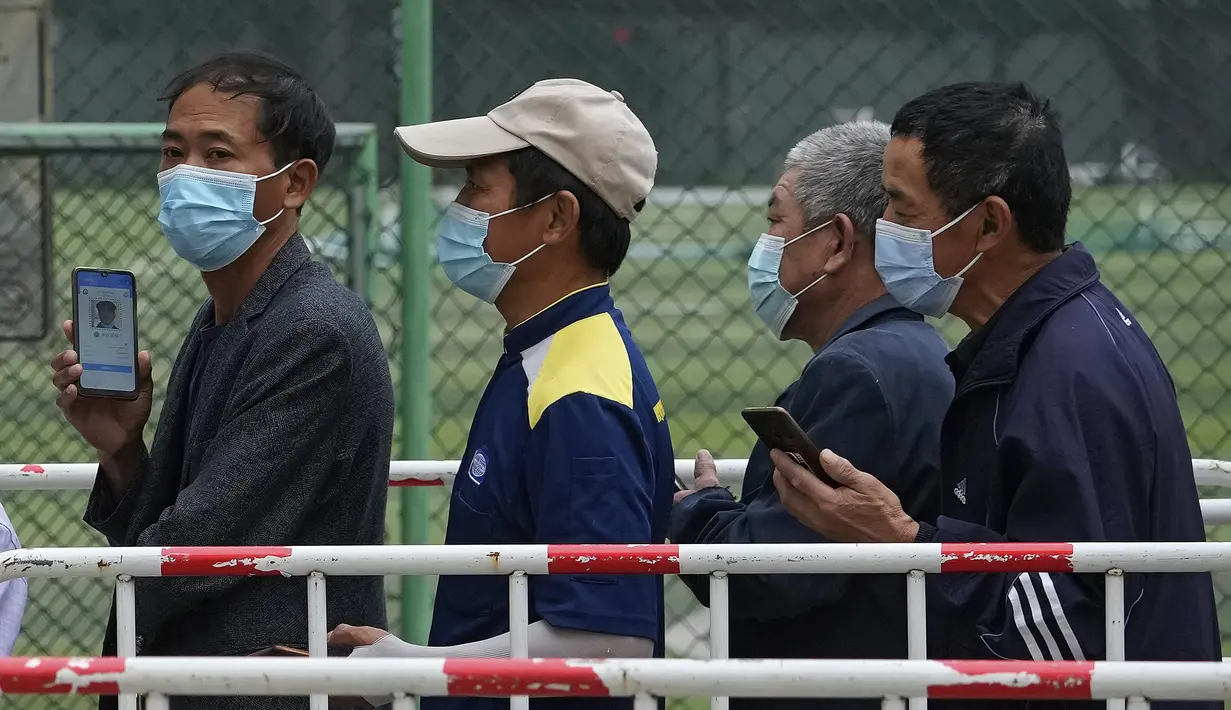 Warga mengenakan masker menunggu untuk memindai kode kesehatan mereka saat mereka mengantre untuk menerima vaksin Sinopharm COVID-19 di Central Business District di Beijing, Rabu (2/6/2021). (AP Photo/Andy Wong)