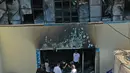 Foto udara menunjukkan orang-orang melihat-lihat bangsal isolasi virus corona yang porak-poranda di rumah sakit Al-Hussein setelah kebakaran, di kota Nasiriyah, Irak selatan, Selasa (13/7/2021). Tragedi yang terjadi Senin malam ini diduga dipicu oleh ledakan tangki oksigen. (Asaad NIAZI/AFP)