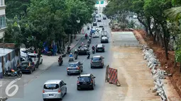 Sejumlah kendaraan melintasi disamping pembangunan jalan di Jakarta, Senin (23/11). Bila kualitas tidak sesuai standar maka Dinas Bina Marga tidak akan memberikan surat rekomendasi ke BPAKD untuk serah terima aset. (Liputan6.com/Yoppy Renato)