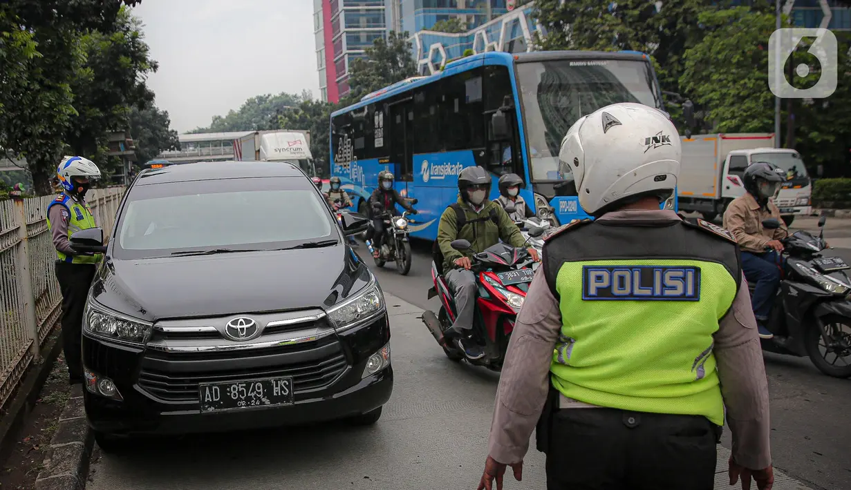 Anggota polisi melakukan penindakan kepada sebuah kendaraan saat ganjil genap di kawasan Jalan D.I Panjaitan, Jakarta, Senin (6/6/2022). Perluasan ganjil genap Jakarta tersebut dilakukan karena volume kendaraan meningkat di Ibu Kota RI tersebut ditiadakan. (Liputan6.com/Faizal Fanani)
