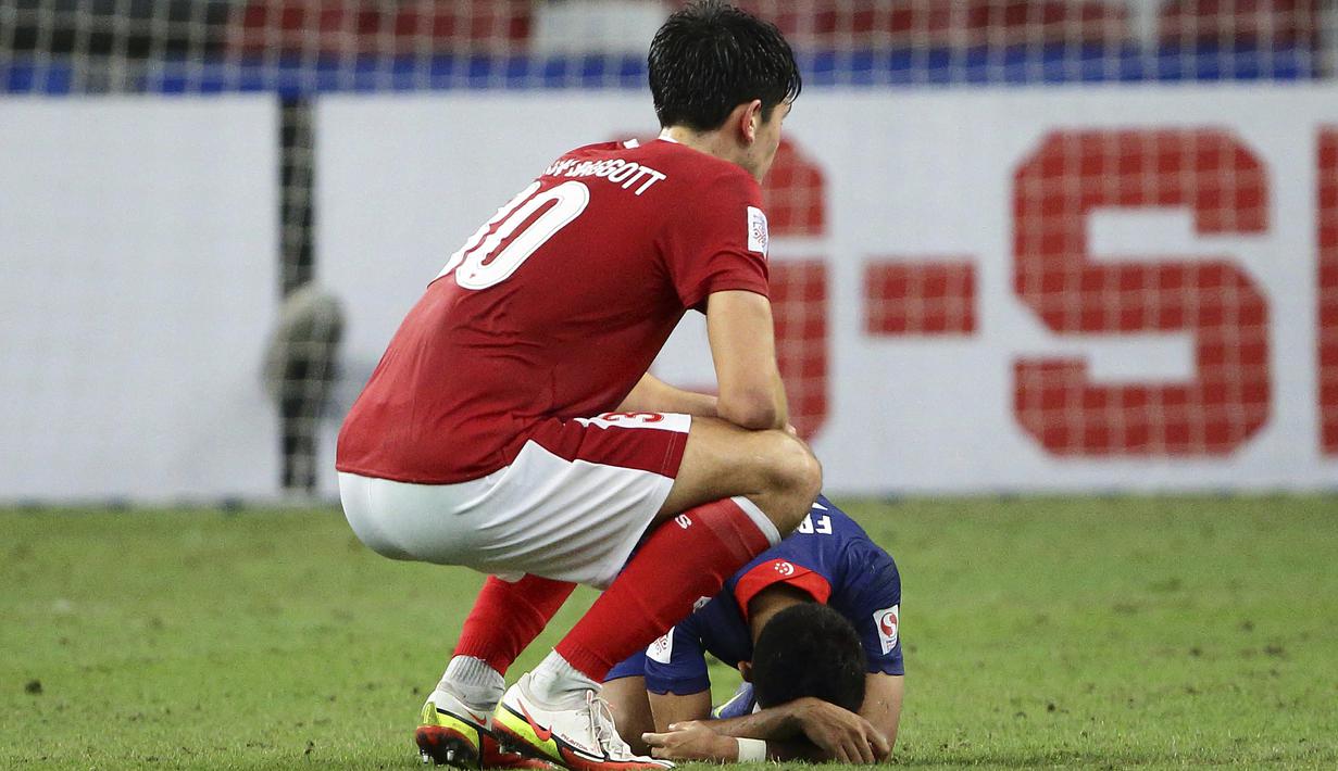 Pemain Timnas Indonesia, Elkan Baggott berusaha menghibur pemain Singapura, Faris Ramli yang masih meratapi kekalahan dari Indonesia. (AP/Suhaimi Abdullah)