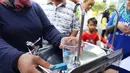 Warga mengambil air minum gratis saat run for water di CFD, Jakarta, Minggu (25/3). Run For Water kolaborasi PAM Jaya, Palyja, dan Aetra mengkampanyekan Hari Air Dunia 2018 mengajak masyarakat ayo peduli air Jakarta. (Liputan6.com/Angga Yuniar)