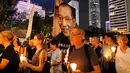 Sejumlah menyalakan lilin untuk mengenang wafatnya penerima Nobel Perdamaian, Liu Xiaobo, di sebuah jalanan di Hong Kong, Sabtu (15/7). Tak hanya menyalakan lilin, mereka pun membawa beragam poster dan spanduk Liu Xiaobo. (AP Photo/Vincent Yu)