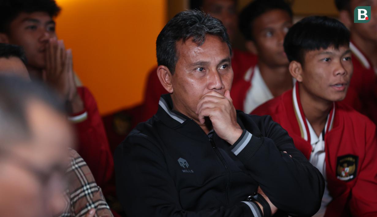 Raut wajah tegang mewarnai pelatih Timnas Indonesia U-17, Bima Sakti (tengah) saat nonton bareng Final Drawing Piala Dunia U-17 2023 yang berlangsung di Zurich, Swiss, dari sebuah restoran di Jakarta, Jumat (16/9/2023). Kekhawatiran dan rasa penasaran terpancar dari semua yang menyaksikan prosesi undian tersebut. (Bola.com/Abdul Aziz)