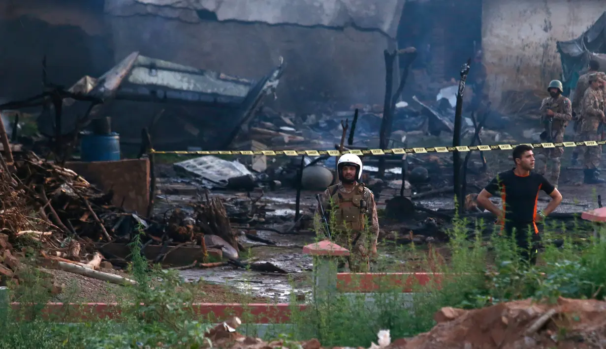 Pejabat militer Pakistan memeriksa lokasi kecelakaan pesawat di Rawalpindi, Pakistan, Selasa (30/7/2019). Pesawat itu sedang dalam misi penerbangan pelatihan yang rutin dijadwalkan. (AP Photo/Anjum Naveed)