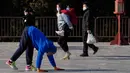 Pengunjung yang memakai masker menyaksikan seorang warga berjalan dengan keempat anggota tubuhnya sebagai bentuk latihan di Temple of Heaven, Beijing, China, Kamis (8/12/2022). China mengumumkan pelonggaran nasional dari pembatasan garis keras COVID-19 pada 7 Desember 2022. (AP Photo/Ng Han Guan)