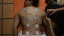 Peraih medali Olimpiade 2016 yang juga atlet BMX asal Venezuela, Stefany Hernandez menjalani terapi stimulasi elektrik ketika perawatan oleh fisioterapis di rumahnya di Caracas pada 25 April 2020. Selain pernah meraih perunggu Olimpiade, Hernandez merupakan juara dunia BMX 2015 (AP/Matias Delacroix)