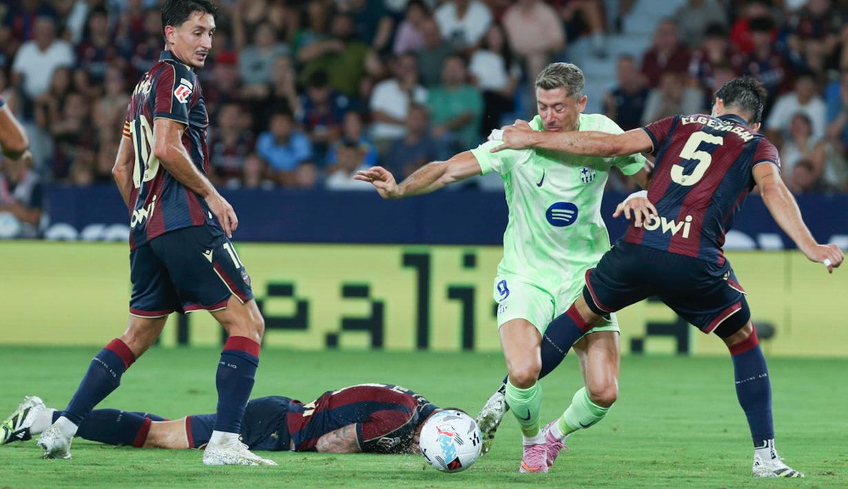 Pemain Barcelona, Robert Lewandowski, berusaha melewati pemain Levante pada jornada kedua La Liga 2025/2026 di Estadio Ciudad de Valencia, Minggu (24/8/2025) dini hari WIB. (AP Photo/Alberto Saiz)