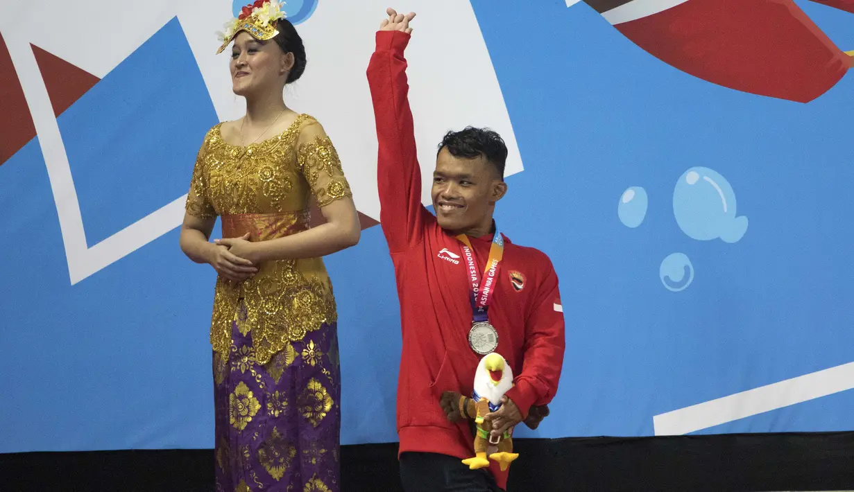 Ekspresi Aris perenang Indonesia yang berhasil meraih medali perak di nomor 100 meter gaya dada klasifikasi SB7 pada Asian Para Games 2018, Gelora Bung Karno Jakarta, Senin (8/10/2018).  (Bola.com/Peksi Cahyo)
