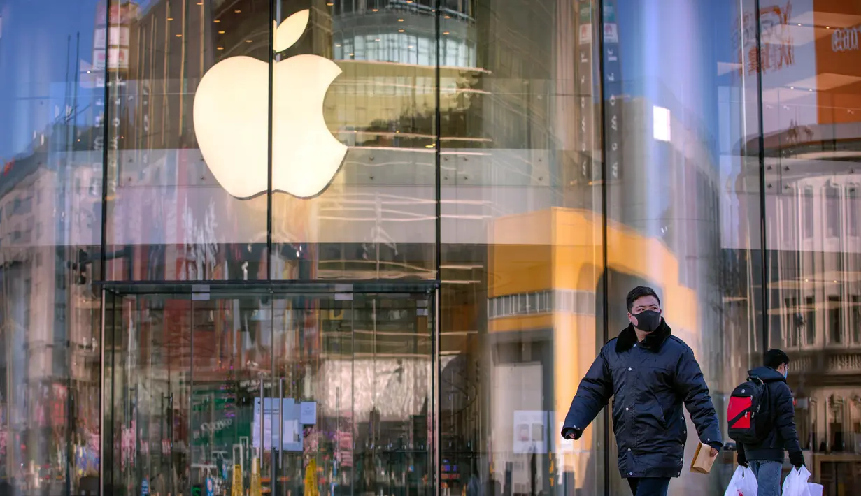 Warga berjalan melewati Apple Store yang tutup di Beijing, China, Selasa (4/2/2020. Belum diketahui bagaimana nasib Apple Store lainnya yang sudah ditutup sejak 1 Februari lalu lantaran wabah virus corona. (AP Photo/Mark Schiefelbein)