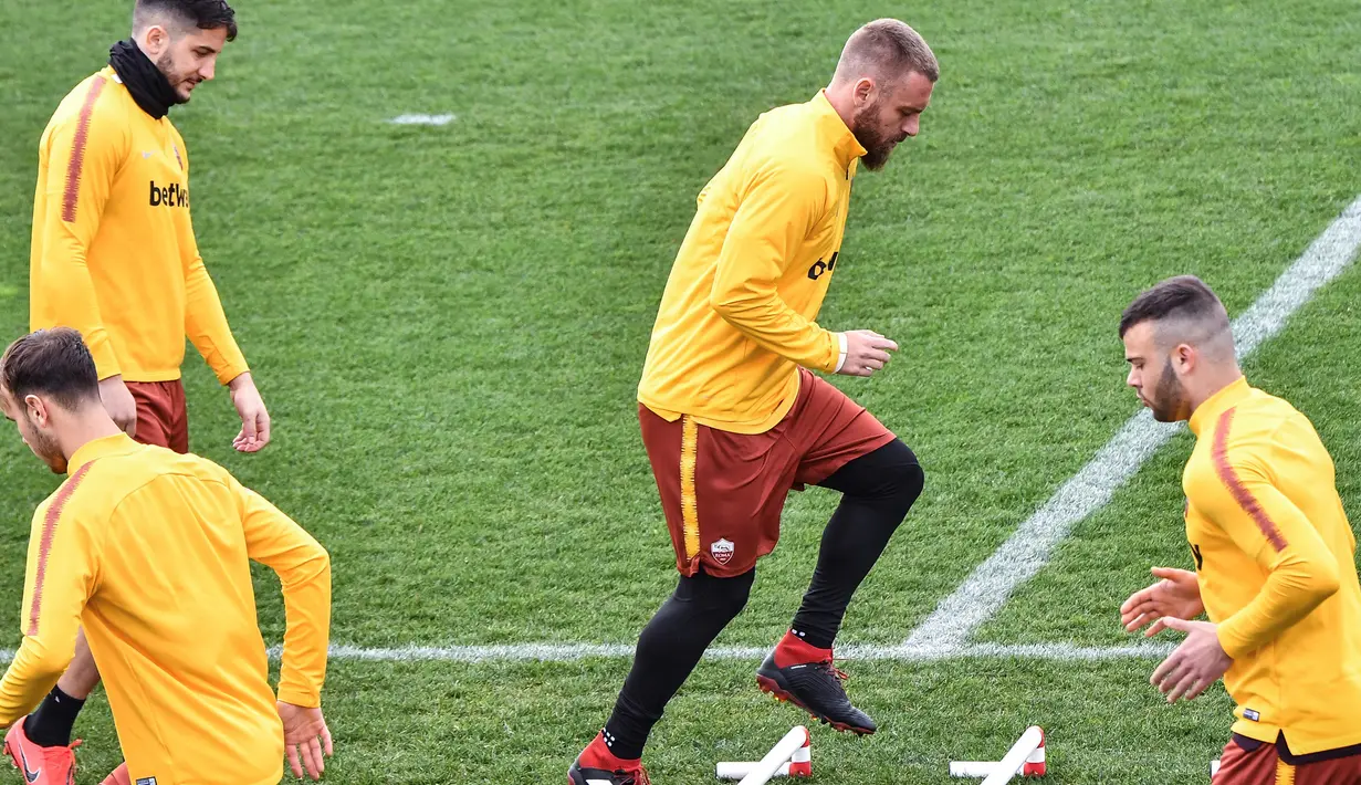 Gelandang AS Roma, Daniele De Rossi melakukan pemanasan saat latihan di Trigoria, selatan Roma (5/3). Roma akan bertanding melawan Porto pada leg kedua babak 16 besar Liga Champions di Estadio do Dragao. (AFP Photo/Andreas Solaro)