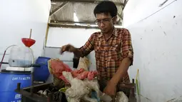Hamidi saat mengolah sampah plastik menjadi bahan bakar di bengkel kerjanya dekat TPA Rawa Kucing, Tangerang, (17/3). Bahan bakarnya tersebut juga dapat untuk menjadi bahan bakar kendaraan. (REUTERS / Beawiharta)
