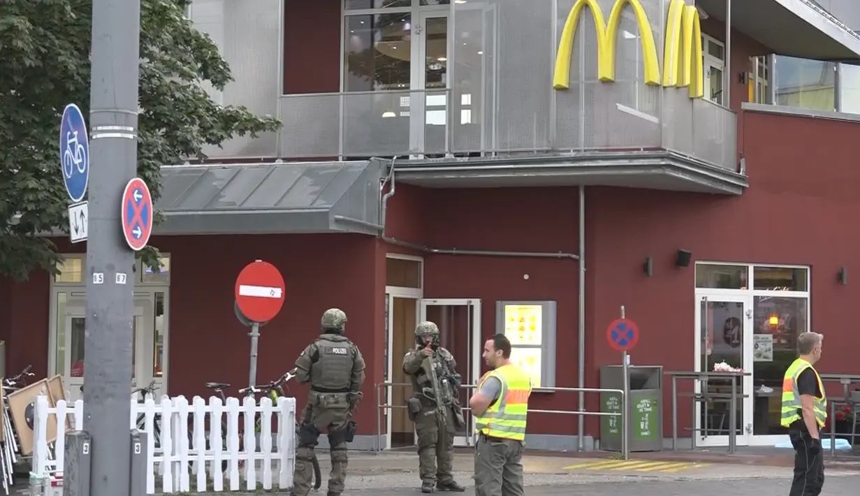 Petugas kepolisian saat mensterilkan kawasan sekitar pusat perbelanjaan Olympia, Munich, Jerman (22/7). Penyerang mulai melepas tembakan pukul 05.50 sore di gerai makanan cepat saji McDonald yang berada di seberang Olympia. (dedinac/Marc Mueller/REUTERS)