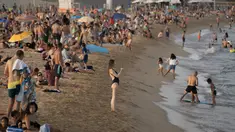 Seorang wanita mengambil foto saat menikmati cuaca panas di pantai di Barcelona, Spanyol, Kamis (12/8/2021). Layanan cuaca nasional Spanyol memperingatkan suhu bisa mencapai 44 derajat Celcius (111 derajat Fahrenheit) di beberapa daerah dalam beberapa hari mendatang. (AP Photo/Joan Mateu Parra)