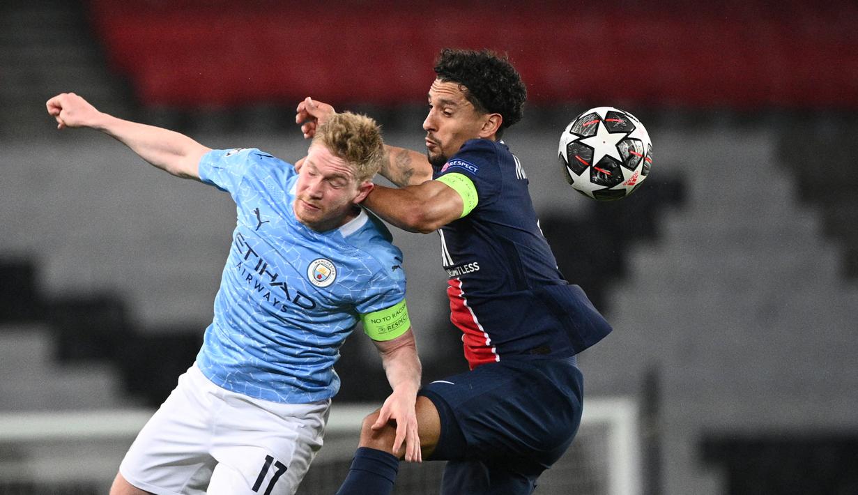 Gelandang Manchester City, Kevin De Bruyne (kiri) berebut bola dengan bek Paris Saint-Germain, Marquinhos dalam laga leg pertama semifinal Liga Champions 2020/2021 di Parc des Princes Stadium, Paris, Rabu (28/4/2021). Manchester City menang 2-1 atas PSG. (AFP/Anne-Christine Poujoulat)