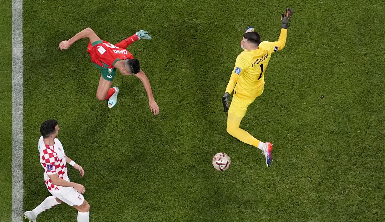 Dua menit berselang Achraf Dari (tengah) berhasil menyundul bola dan mengelabui penjaga gawang Kroasia, Dominik Livakovic (kanan). (AP Photo/Pavel Golovkin)
