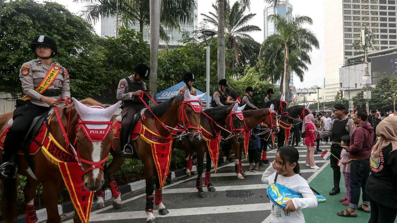 Seorang anak melihat Polisi Berkuda dari Detasemen Turangga Direktorat Polisi Satwa Polri yang dihadrikan pada Hari Bebas Kendaraan Bermotor di kawasan Bundaran HI, Jakarta, Minggu (13/8/2023).