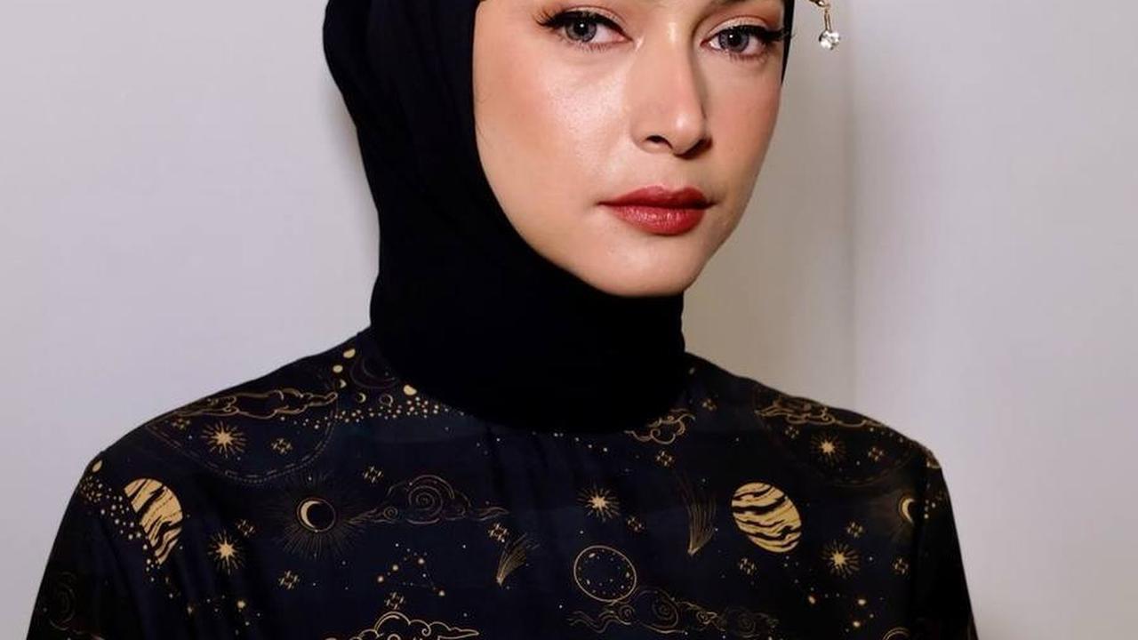 Penampilannya semakin sempurna dengan headpiece emas cantik dan unik yang menambah pesona keanggunannya.<br>