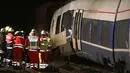 Petugas pemadam kebakaran berdiri di samping gerbong yang rusak usai terjadinya tabrakan dengan kereta lainnya di Meerbusch, Jerman, (5/12). Puluhan penumpang alami luka-luka dan tidak ada korban jiwa. (Arnulf Stoffel / dpa via AP)