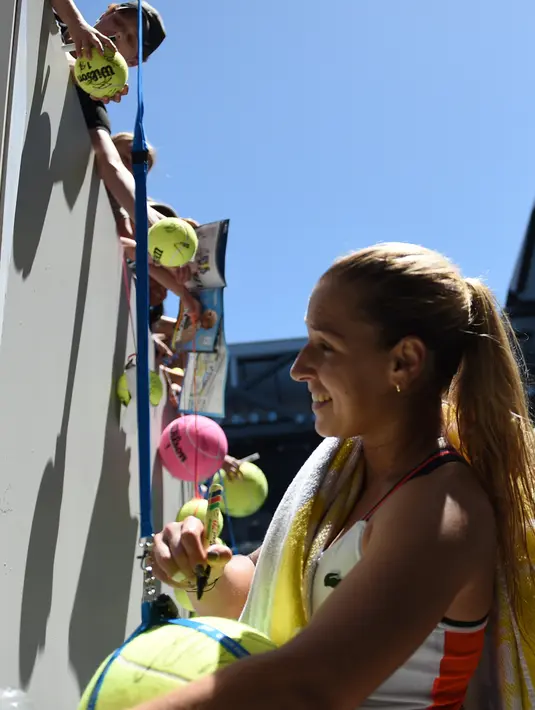 Petenis Slowakia Dominika Cibulkova membubuhkan tanda tangan di bola tenis penggemarnya setelah memenangkan pertandingan putaran kedua Australia Terbuka melawan petenis Taiwan Hsieh Su-Wei di Melbourne, Rabu (18/1). (AFP PHOTO/SAEED KHAN)
