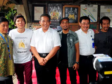 Personel grup band Slank dan manager Slank, Bunda Iffet (kanan) berpose bersama petugas BNN usai melakukan pertemuan di Markas Slank, Gang Potlot, Jakarta, Selasa (17/3/2015). (Liputan6.com/Yoppy Renato)