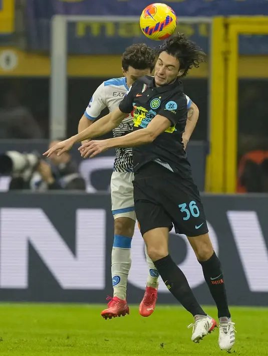 Bek Napoli Mario Rui dan bek Inter Milan Matteo Darmian  melompat saat berebut bola dalam lanjutan Liga Italia di Giuseppe Meazza, Senin (22/11/2021) dini hari WIB. Inter Milan sukses mengandaskan Napoli dengan skor tipis 3-2. (AP Photo/Antonio Calanni)