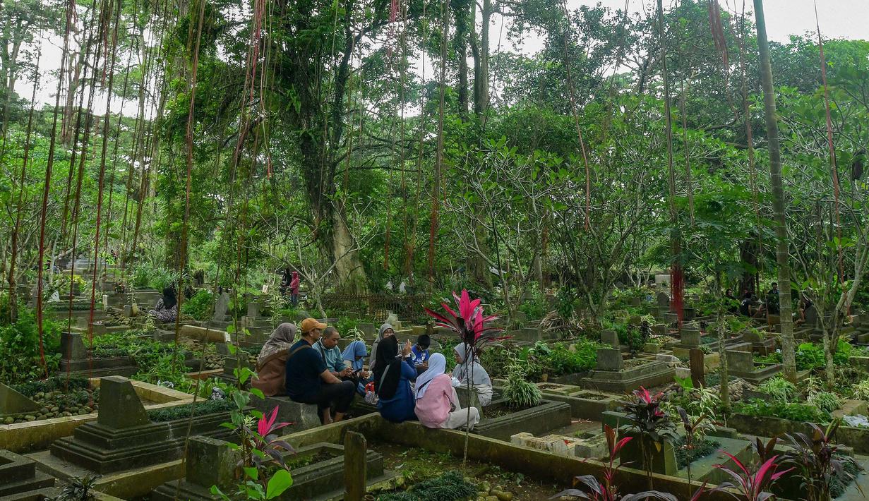 Warga saat berziarah di makam keluarganya di Tempat Pemakaman Umum (TPU) Dreded, Bogor, Jawa Barat, Minggu (15/2/2026). (merdeka.com/Arie Basuki)