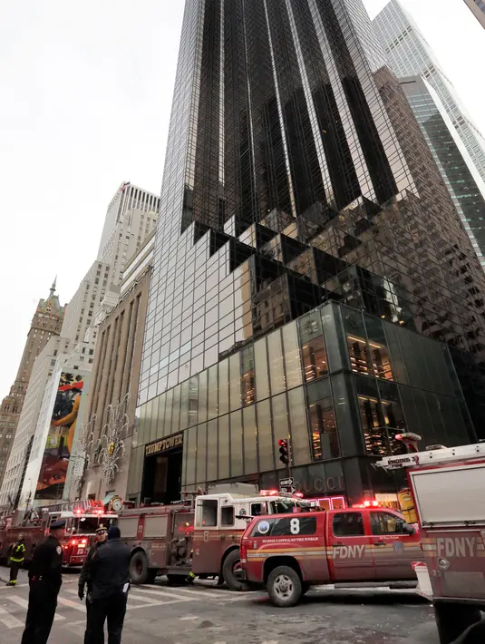 Petugas pemadam kebakaran New York bergegas menuju Trump Tower di Fifth Avenue setelah menerima panggilan terjadi kebakaran di lokasi tersebut, Senin (8/1). Terkait sebab kebakaran, pihak pemadam masih melakukan investigasi. (AP Photo/Richard Drew)