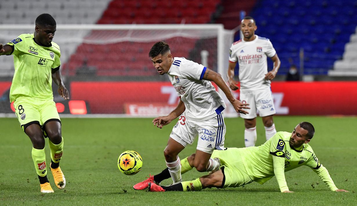 Gelandang Olympique Lyon, Bruno Guimaraes, berebut bola dengan pemain Dijon pada laga Ligue 1 di Stadion Groupama, Sabtu (29/8/2020) dini hari WIB. Lyon menang 4-1 atas Dijon. (AFP/Philippe Desmazes)