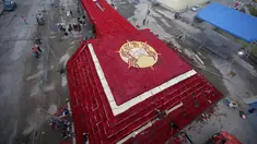 Penduduk setempat menyelesaikan pembuatan piramida Cochasqui dari bunga mawar dalam upaya pemecahan Guinness World Records di Tabacundo, Ekuador, 20 Juli 2018. Piramida dibangun di lahan seluas 1.100 meter tanpa henti oleh para relawan (AP/Dolores Ochoa)