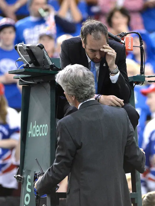 Kepala wasit menanyakan keadaan wasit Arnaud Gabas, setelah terkena bola tenis saat petenis Kanada Denis Shapovalov melawan Kyle Edmund dari Inggris pada putaran pertama Piala Davis di Ottawa, Kanada, Minggu (5/2). (Justin Tang/The Canadian Press via AP)