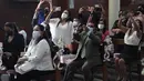 Orang tua, mengenakan masker pelindung, mengambil foto upacara Perjamuan Kudus pertama anak-anak mereka di tengah pandemi virus corona baru di gereja Katolik Nuestra Senora de la Merced di Lima, Peru, Jumat (3/12/2021). (AP Photo/Martin Mejia)