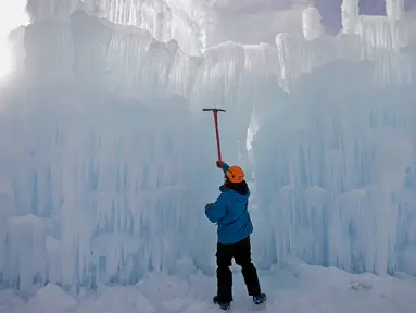 Seorang pekerja memahat dinding es saat mebuat kastel atau Istana Es di Midway, Utah (27/12). Nantinya pengunjung akan dapat menikmati Istana Es yang terdiri dari labirin, ngarai atau lembah, terowongan dan air mancur. (AP/Rick Bowmer)