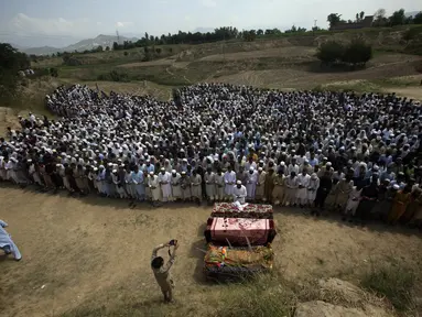 Kerabat dan pelayat menghadiri doa pemakaman para korban yang tewas dalam serangan bom bunuh diri hari Minggu di distrik Bajur, Khyber Pakhtunkhwa, Pakistan, Senin, 31 Juli 2023. (AP Photo/Mohammad Sajjad)