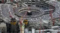 Pemandangan menunjukkan jamaaH berdoa di Masjidil Haram dikelilingi crane konstruksi di Mekah, 14 Juli 2015. Sebuah crane jatuh di Masjidil Haram pada Jumat (11/9), dan menyebabkan sekitar 107 orang tewas, termasuk WNI. (REUTERS/Ali Al Qarni/Files)