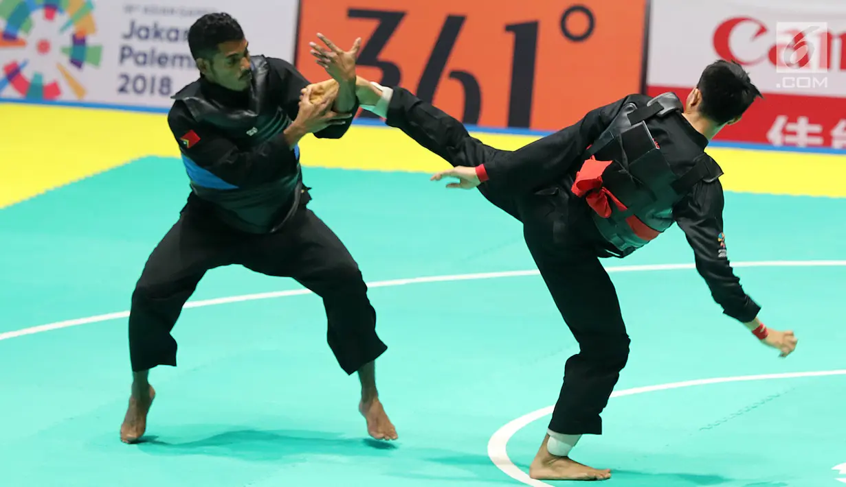 Pesilat Indonesia, Komang Harik Adiputra melepas tendangan ke arah pesilat Timor Leste, David No-Ano Ximenes pada kelas 65-70 kg Putra Asian Games 2018 di Padepokan Pencak Silat TMII, Jakarta, Kamis (23/8). Komang unggul 5-0. (Liputan6.com/Fery Pradolo)