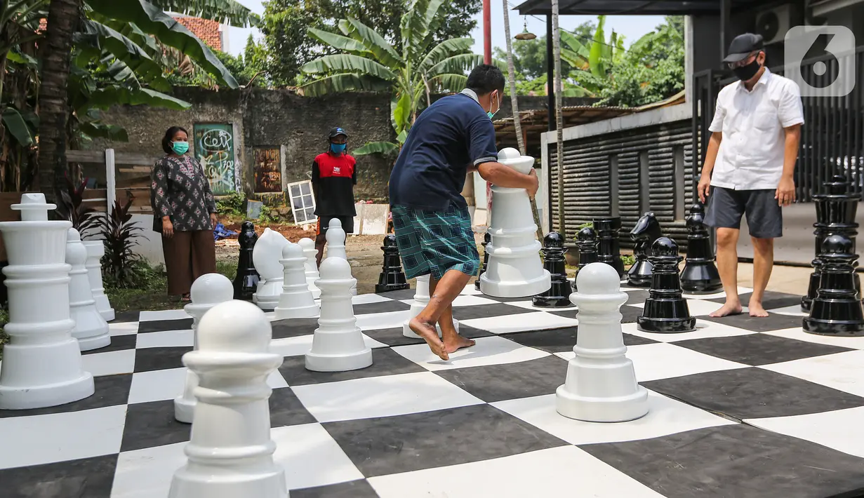 Warga bermain catur raksasa sambil menunggu waktu berbuka puasa di Pondok Betung, Tangerang Selatan, Kamis (14/5/2020). Catur berukuran raksasa dengan luas lapangan 4,8m x 4,8m dilakukan warga untuk mengisi kegiatan selama Pembatasan Sosial Berskala Besar (PSBB). (Liputan6.com/Fery Pradolo)